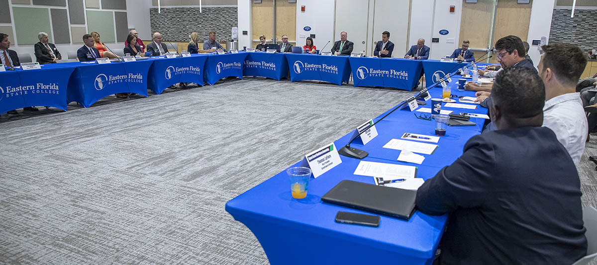 tables with EFSC logo and people sitting at them in large room